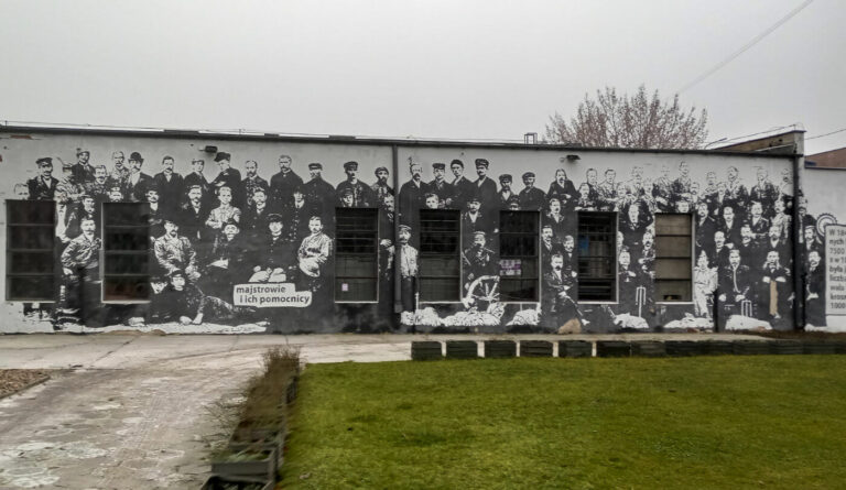 Mural przedstawiający majstrów i ich pomocników przy wejściu do Muzeum Lniarstwa